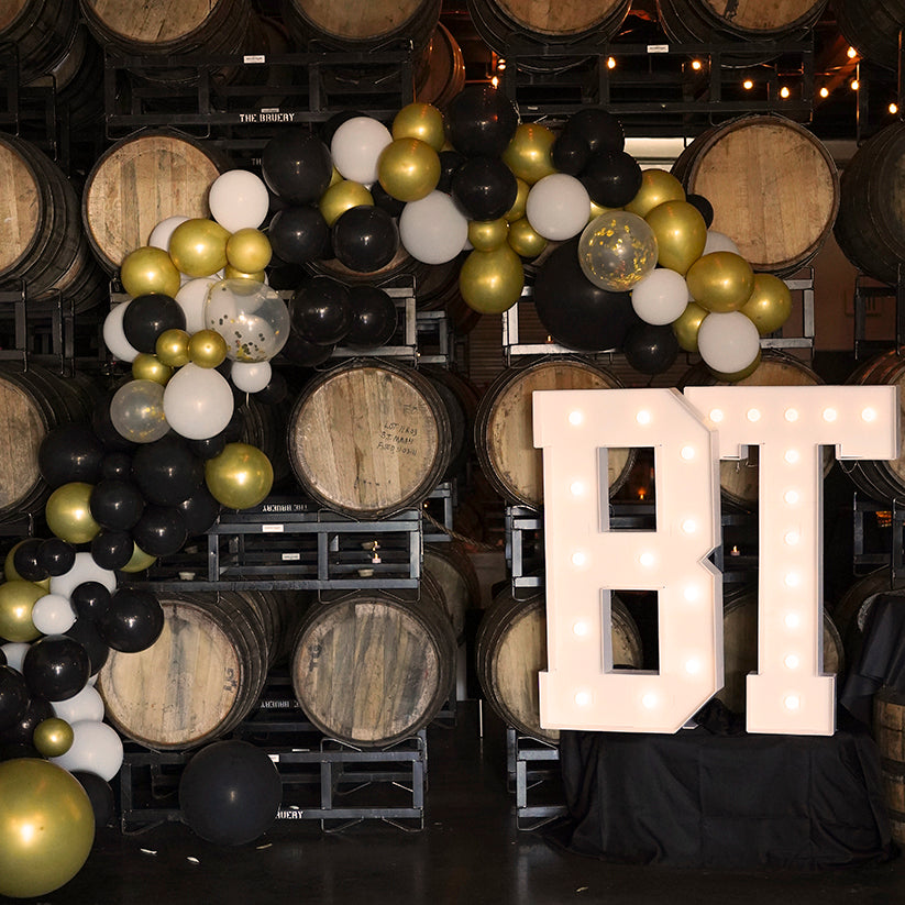 Decorative balloons and illuminated letters in a barrel storage area